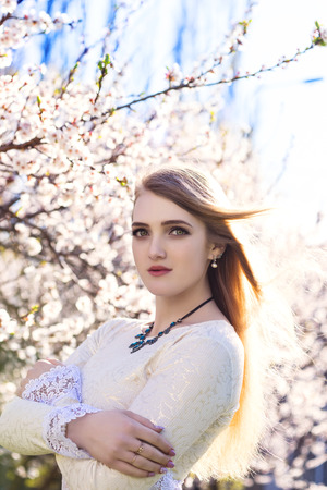 Young beautiful tender woman in a spring garden on the flowering backgroundの写真素材