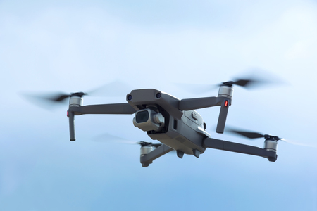 Flying quadcopter with digital camera in the sky with cloudsの写真素材