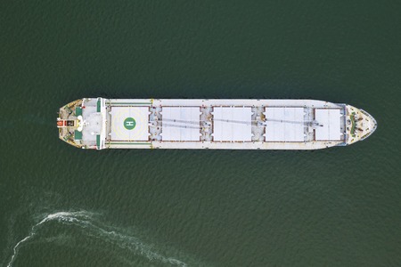 Aerial top view cargo ship in import export business logistic and transportation of international by ship cargo ship in the open sea, with copy spaceの写真素材