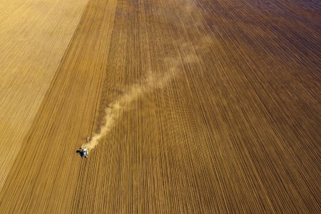 Harvester working in the field at spring and plowing the fieldの写真素材