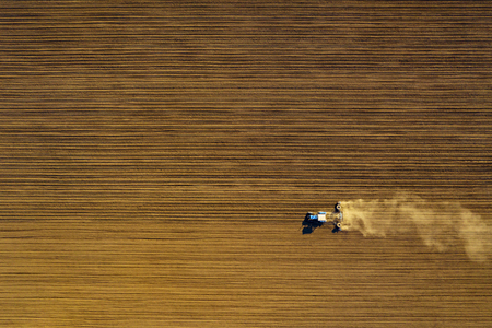 Harvester working in the field at spring and plowing the fieldの写真素材