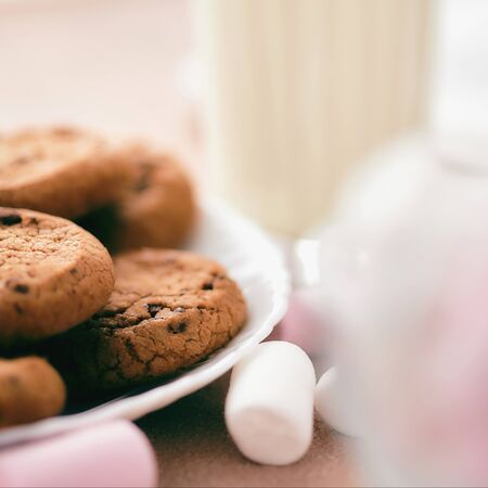 Chocolate cakes on the light table with milk and marshmallows