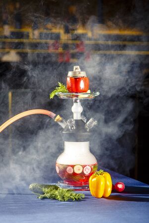 Hookah on vegetables. Hookah with a round transparent flask, which contains chopped vegetables:...
