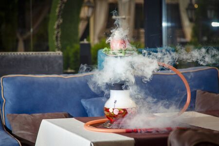 Hookah on vegetables. Hookah with a round transparent flask, which contains chopped vegetables:...