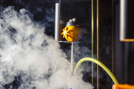 Preparation of hookah on the bar. The bartender adds clear liquor to the hookah flask. In the flask...