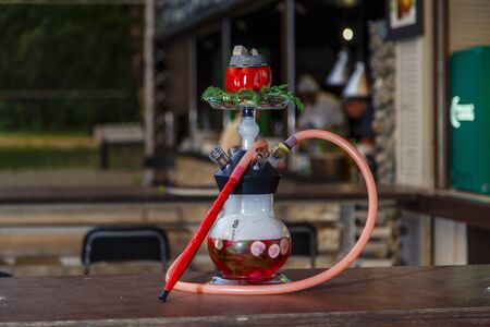 Hookah on vegetables. Hookah with a round transparent flask, which contains chopped vegetables:...