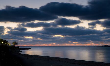 Evening winter beach in Gelendzhik. Blue evening. Long exposure. Clouds. Mountains in the...