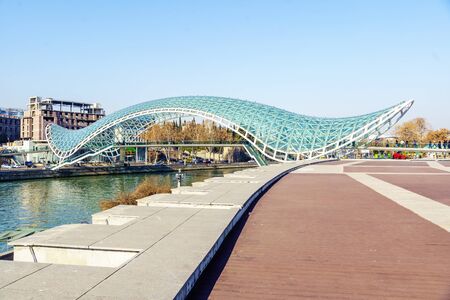 Georgia, Tbilisi-peace bridge over the Kura river. Beautiful glass bridge. Local residents do not particularly like it and call it "women's pad" or "diapers". It really looks like a woman's pad. This is a pedestrian bridge, which makes it pleasant foの写真素材