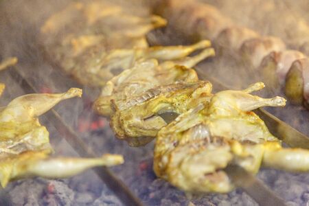 Quail on the grill. Several quails are strung on a skewer and fried on coals. Quail on the grill....