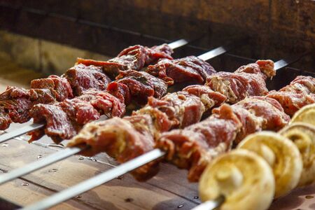 Raw meat strung on a skewer and prepared for frying on the grill.