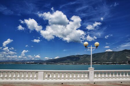 Gelendzhik embankment on the background of the Caucasus mountains. Balustrade, clear weather, blue...