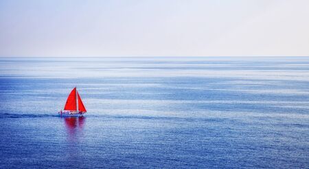 A ship with scarlet sails sails on a blue sea on a summer day.の写真素材