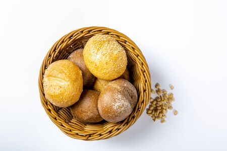 Wicker bread basket with white and rye round loaves. On white backgroundの写真素材