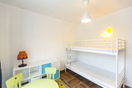 Children's room in the cottage. Bunk bed, window with blue curtains, large wardrobe with yellow...