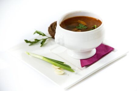 Borscht with pampushka, onion and garlic. Plate on a white background.