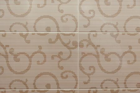 Beige ceramic tile with a plant pattern.