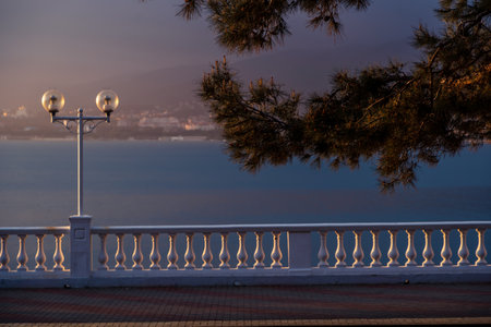 The setting sun very beautifully and contrastingly highlights the balustrade of the embankment of...
