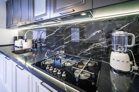 New stylish kitchen with black countertop and white appliances. Black and white cabinet doors.の写真素材