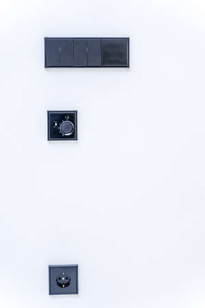 Stylish black light switches on the wall in a newly renovated room.の写真素材
