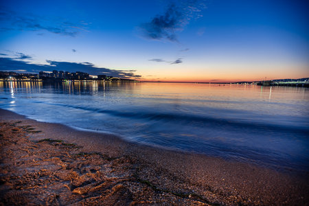 The beach of the resort of Gelendzhik resort after sunset on a long exposure. Reflection of lights in the Gelendzhik Bay The beach is empty, with no people in sight. The scene is peaceful and sereneの写真素材