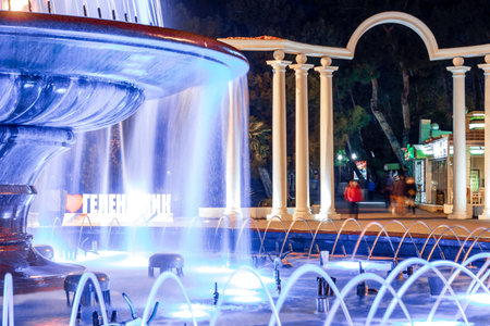 Gelendzhik resort embankment in the evening. A singing fountain and the inscription "I love Gelendzhik" in the background. The fountain is lit up at night, creating a beautiful and serene atmosphereの写真素材