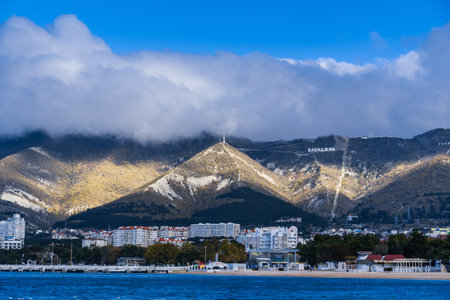Gelendzhik resort in winter. Nord-Ost wind begins. Signs of storm - clouds over Caucasus Mountains. Off-season. Deserted beach, strong wind.の写真素材
