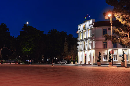 Gelendzhik City Administration Building at night. A large building with a white roof and a large moon in the sky.の写真素材