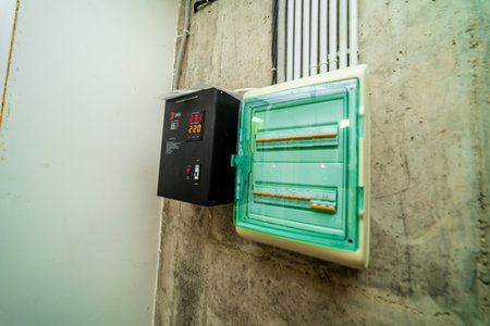 A black box with a digital display that reads 3.2 sits next to a green box. The black box is likely...