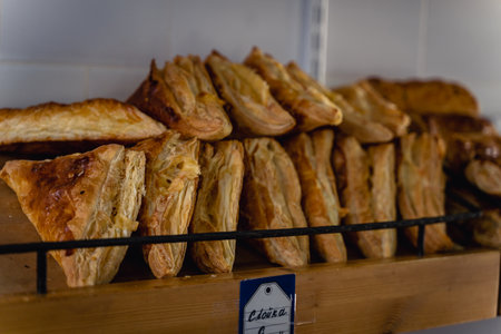 Various fresh and delicious pastries are on counter. The pastries are arranged in two trays.