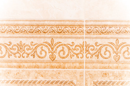 A wall with a decorative border that has a floral design. The border is made up of small, intricate...
