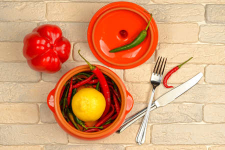 chili pepper in a ceramic pot on a brick background