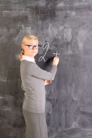 Young teacher stands at the blackboard, is a lessonの写真素材