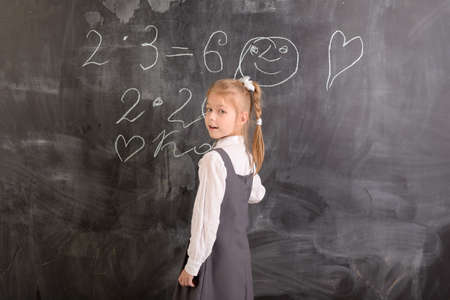 Student writes with chalk on a blackboardの写真素材