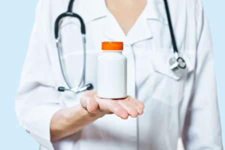 doctor holding bottle of pills on white background. The concept of medicine, pharmacology,...