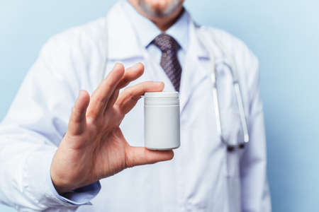 doctor holding bottle of pills on white background. The concept of medicine, pharmacology, healthcareの写真素材