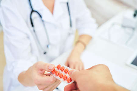 Prescription from a doctor for treatment for diseases. Doctor giving blue medicine pills. pharmacology conceptの写真素材