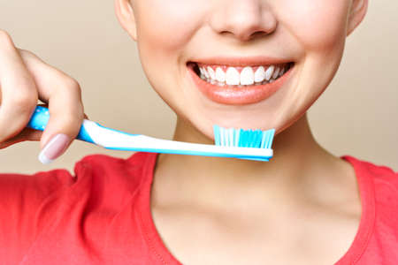 Young beautiful woman is engaged in cleaning teeth. Beautiful smile healthy white teeth. A girl...
