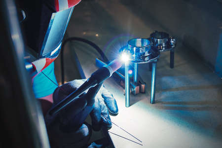 Mens hands with argon welding machine. repair pipe stainless argon welding industrial construction