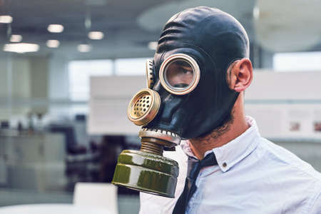 Coronavirus quarantine. Young office employee, at work in a full-face mask. Infection protection.の写真素材