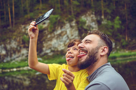 Having fun. Father example of noble human. Taking selfie with son. Child riding on dads shoulders. Happiness being father of boy.の写真素材