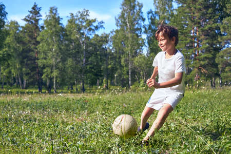 kid kicking a soccer ball on the field