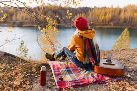 Hike to nature. Girl enjoying the view of the autumn riverの写真素材