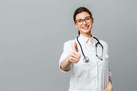 Portrait of a happy female doctor with a stethoscope showing the OK signの写真素材