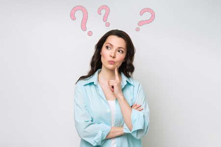 A confused woman stands uncertainly, shrugs her shoulders, cant give an answer to a difficult...