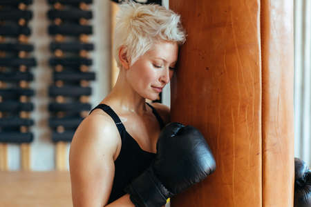 A female boxer and a boxing bag. The concept of a strong woman.の写真素材
