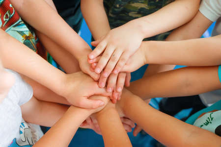 Team building. Childrens hands. Group activity for children. The concept of achieving a common goal in a team.の写真素材