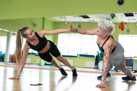 A young woman is doing fitness with a trainer at the GYM