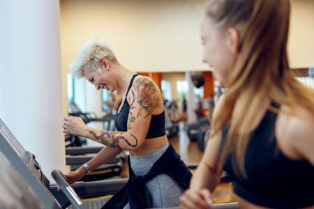 A young woman is doing fitness with a trainer at the GYMの写真素材