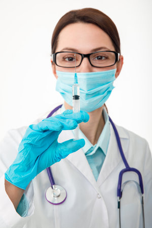A nurse holds a syringe before giving an injection. The concept of vaccination.の写真素材