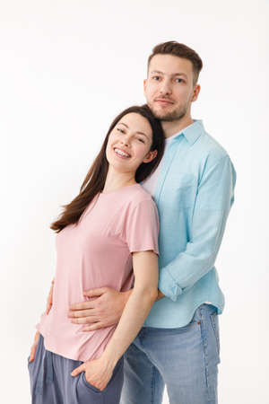 Portrait of a beautiful beloved couple. A guy and a girl hug each other and look at the camera smiling . On a white backgroundの写真素材